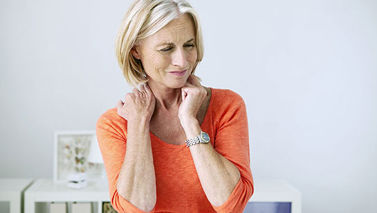 Mature woman suffering from neck and shoulder pain before visiting Akron chiropractor